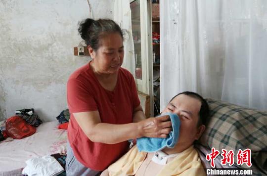 每次喂完食物后，梁青蘭都要仔細地幫兒子清理干凈?！∩忻鱾b 攝