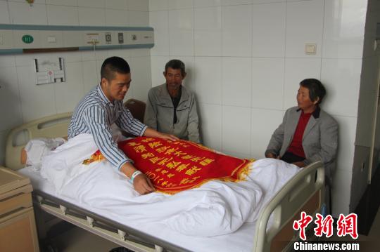 被救的李忠起、張總鳳夫婦看望受傷后的李運(yùn)飛。　汪渝 攝