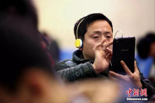 資料圖：候車室內(nèi)，玩手機(jī)的&ldquo;低頭族&rdquo;隨處可見(jiàn)。刷微博、聊微信、玩游戲、看電影，高科技將大多旅客變?yōu)槭謾C(jī)&ldquo;低頭族&rdquo;。<a target='_blank' ><p  align=