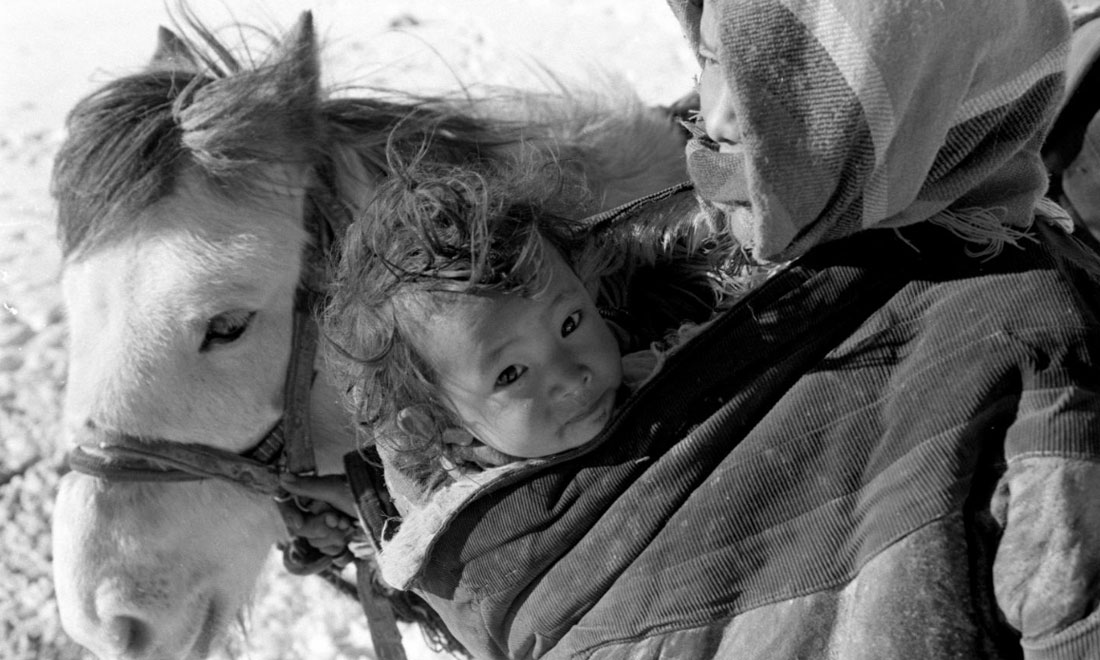 1990年3月，西藏當雄縣納木湖鄉(xiāng)三村女牧民斯卓不畏嚴寒，懷抱幼子，準備到遠處放牧。新華社記者覺果攝