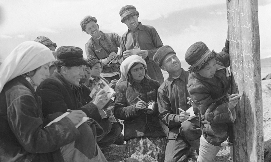 1960年6月，新疆慕士塔格峰下，大人們在小學生幫助下學習文化。新華社記者武純展攝