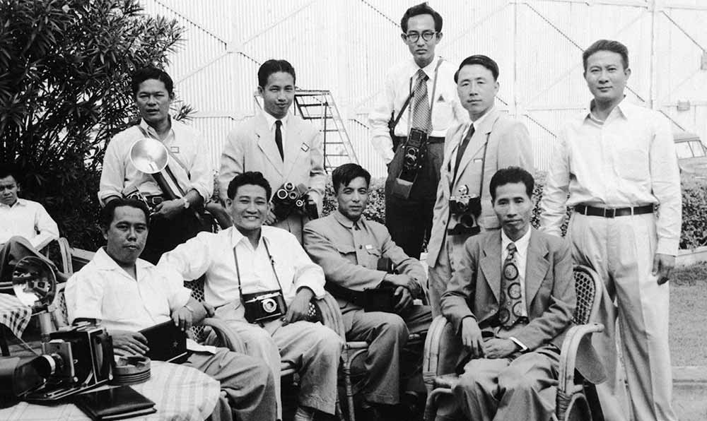 新華社記者錢嗣杰（站立者右二）在采訪會(huì)議開幕式后和外國記者在會(huì)場(chǎng)外休息。